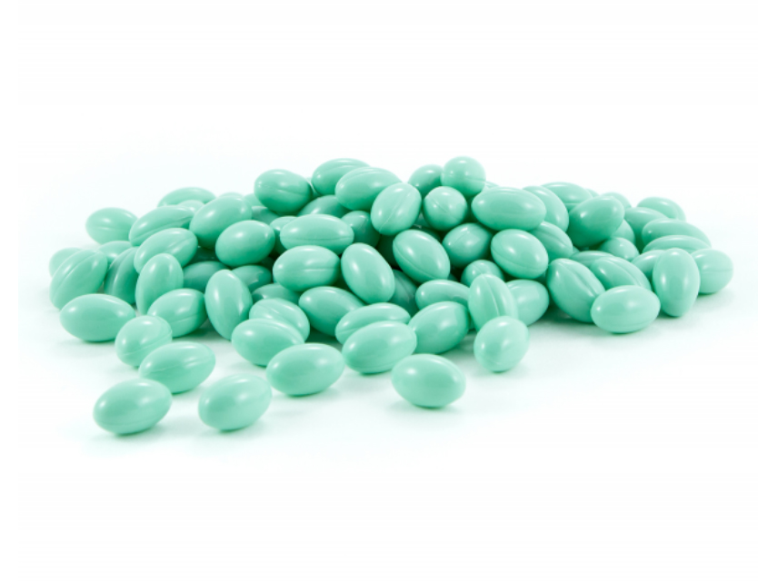 capsulas de biotina jogada fundo verde